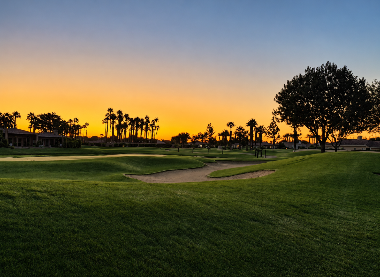 Golf course at Solmirage beneath a golden desert sunset.