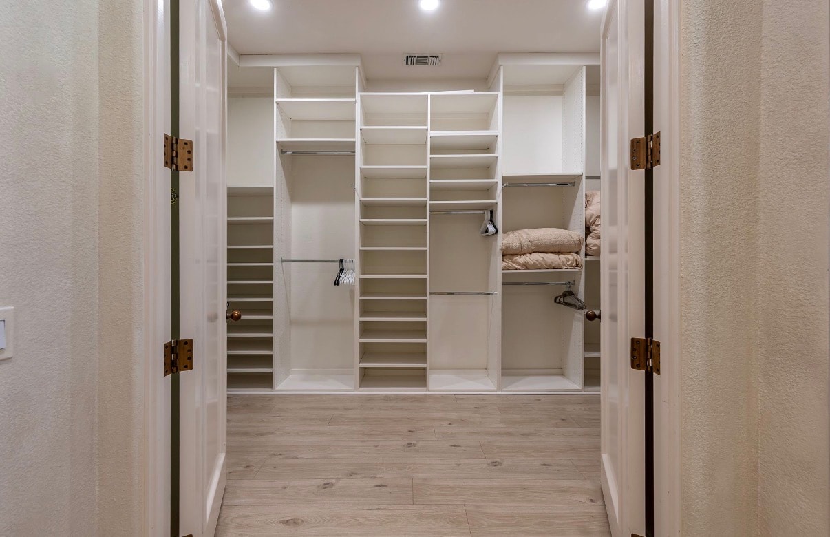 Spacious walk-in closet at Solmirage with custom built-in shelving and storage.